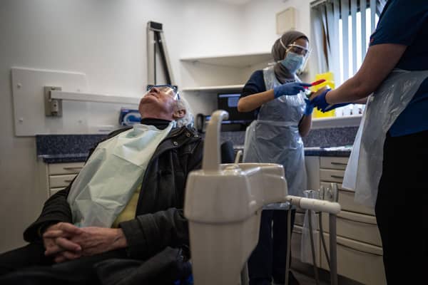 A dentist treating a patient while in PPE.