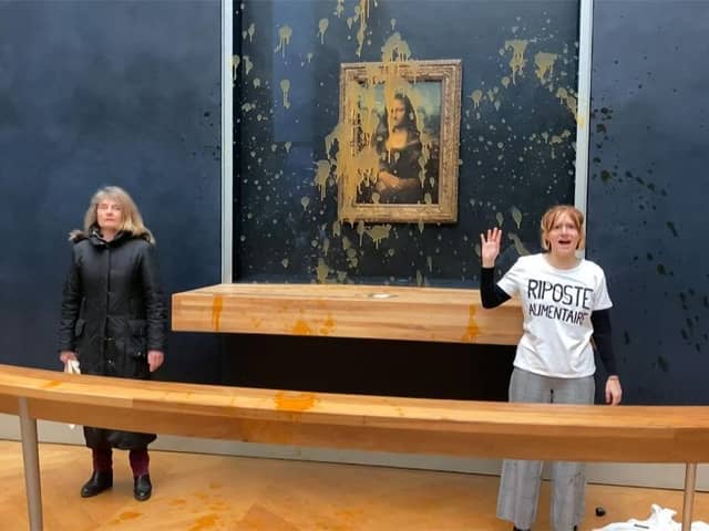 Two environmental activists from the collective dubbed "Riposte Alimentaire" (Food Retaliation) stand in front of Leonardo Da Vinci's "Mona Lisa" painting after hurling soup at the artwork, at the Louvre museum in Paris.