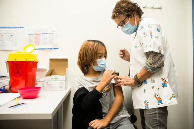 HADERA, ISRAEL - NOVEMBER 24:  Israeli child Liron Nurjits, 11, recieves a Pfizer-BioNTech Covid-19 vaccine from a Clalit health provider worker on November 24, 2021 in Hadera, Israel. People aged 12 and up in Israel are already eligible for the two-dose Pfizer-BioNTech vaccine and a follow-up booster.  (Photo by Amir Levy/Getty Images)