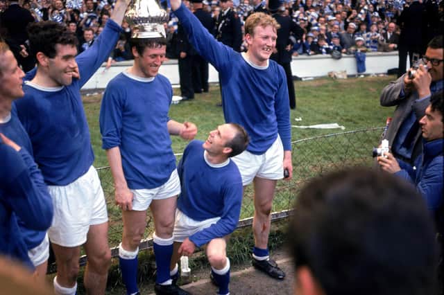 Jimmy Gabriel (r) helps crown teammate Brian Harris (c) with the FA Cup after the 3-2 comeback win over Sheffield Wednesday in 1966