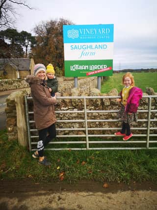 Eilidh and her kids at farm signpost