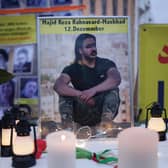 A photograph of Majidreza Rahnavard, 23, stands on a table among candles during a demonstration by supporters of the National Council of Resistance of Iran in Berlin (Picture: Sean Gallup/Getty Images)