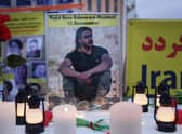 A photograph of Majidreza Rahnavard, 23, stands on a table among candles during a demonstration by supporters of the National Council of Resistance of Iran in Berlin (Picture: Sean Gallup/Getty Images)