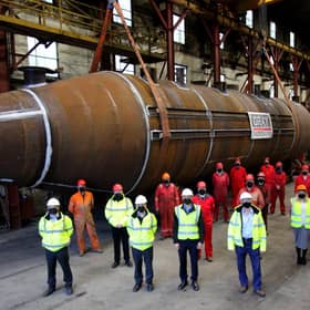Masked workers at Grey Fabrication yard in Dundee pose with the main body of what will become the world's most powerful tidal turbine, due to be launched next spring once fully assembled