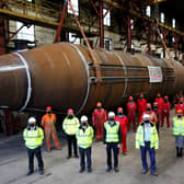 Masked workers at Grey Fabrication yard in Dundee pose with the main body of what will become the world's most powerful tidal turbine, due to be launched next spring once fully assembled