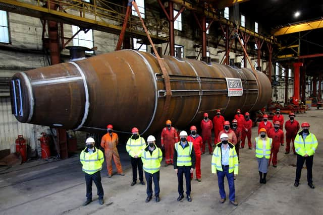 Masked workers at Grey Fabrication yard in Dundee pose with the main body of what will become the world's most powerful tidal turbine, due to be launched next spring once fully assembled