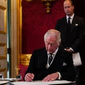 Prince William, Prince of Wales and Camilla, Queen Consort watch as King Charles III signs an oath to uphold the security of the Church in Scotland, during a meeting of the Accession Council inside St James's Palace in London