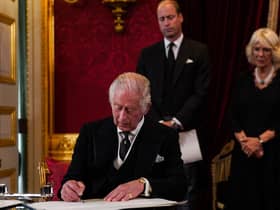 Prince William, Prince of Wales and Camilla, Queen Consort watch as King Charles III signs an oath to uphold the security of the Church in Scotland, during a meeting of the Accession Council inside St James's Palace in London