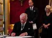 Prince William, Prince of Wales and Camilla, Queen Consort watch as King Charles III signs an oath to uphold the security of the Church in Scotland, during a meeting of the Accession Council inside St James's Palace in London
