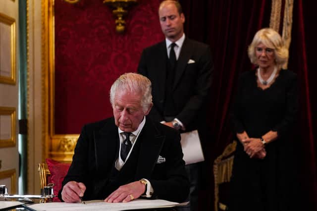 Prince William, Prince of Wales and Camilla, Queen Consort watch as King Charles III signs an oath to uphold the security of the Church in Scotland, during a meeting of the Accession Council inside St James's Palace in London