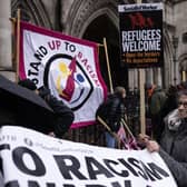 'Stand up to Racism' campaigners dismantle a flag after staging an anti-Rwanda deportations demo outside the Royal Courts of Justice. Picture: Dan Kitwood/Getty Images