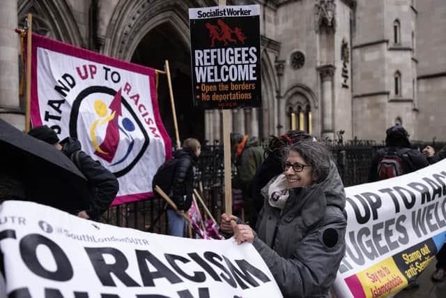 'Stand up to Racism' campaigners dismantle a flag after staging an anti-Rwanda deportations demo outside the Royal Courts of Justice. Picture: Dan Kitwood/Getty Images