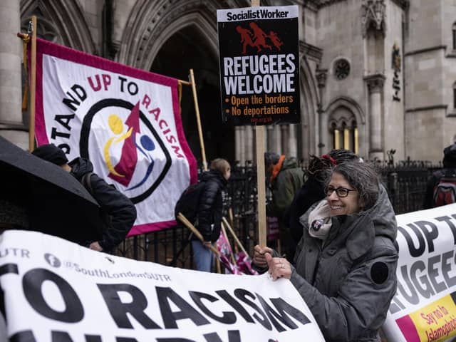 'Stand up to Racism' campaigners dismantle a flag after staging an anti-Rwanda deportations demo outside the Royal Courts of Justice. Picture: Dan Kitwood/Getty Images