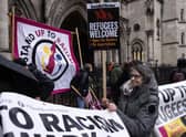 'Stand up to Racism' campaigners dismantle a flag after staging an anti-Rwanda deportations demo outside the Royal Courts of Justice. Picture: Dan Kitwood/Getty Images