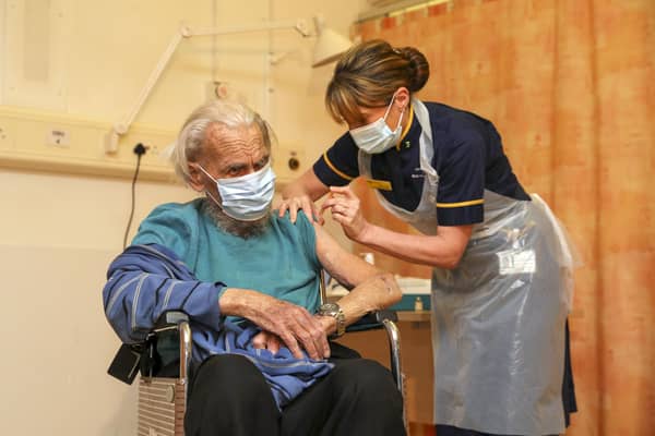 88-year-old Trevor Cowlett receives the Oxford University/AstraZeneca Covid-19 vaccine from nurse Sam Foster. Picture: PA