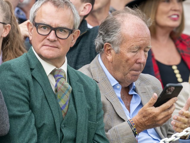 Actor Hugh Bonneville (centre) watching the Braemar Royal Highland Gathering at the Princess Royal and Duke of Fife Memorial Park in Braemar.