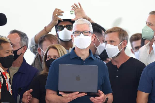 Apple chief executive Tim Cook (centre) holds a newly redesigned MacBook Air laptop. Picture: Justin Sullivan/Getty Images