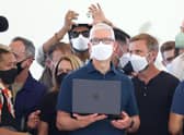 Apple chief executive Tim Cook (centre) holds a newly redesigned MacBook Air laptop. Picture: Justin Sullivan/Getty Images