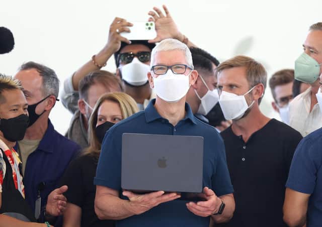 Apple chief executive Tim Cook (centre) holds a newly redesigned MacBook Air laptop. Picture: Justin Sullivan/Getty Images