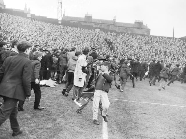 Police are swamped by supporters invading the pitch at Tynecastle Park, Edinburgh, during the Hearts v Celtic match in March 1966.