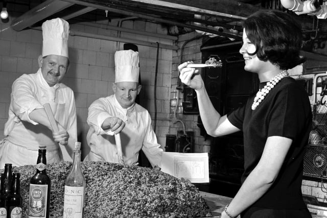 A 340lb Christmas pudding being mixed by Pastry chef Danny Morton and second chef William Milne - and being tasted by receptionist Olivia Renylel -  at the Caledonian Hotel, in Edinburgh, in 1965.
