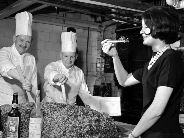 A 340lb Christmas pudding being mixed by Pastry chef Danny Morton and second chef William Milne - and being tasted by receptionist Olivia Renylel - at the Caledonian Hotel, in Edinburgh, in 1965.