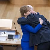 Outgoing First Minister Nicola Sturgeon and outgoing Deputy First Minister John Swinney hug before leaving the main chamber after her last First Minster's Questions (FMQs) in the main chamber of the Scottish Parliament in Edinburgh.