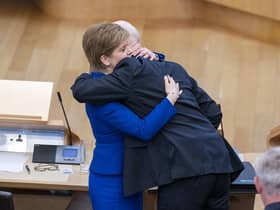 Outgoing First Minister Nicola Sturgeon and outgoing Deputy First Minister John Swinney hug before leaving the main chamber after her last First Minster's Questions (FMQs) in the main chamber of the Scottish Parliament in Edinburgh.
