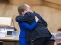 Outgoing First Minister Nicola Sturgeon and outgoing Deputy First Minister John Swinney hug before leaving the main chamber after her last First Minster's Questions (FMQs) in the main chamber of the Scottish Parliament in Edinburgh.