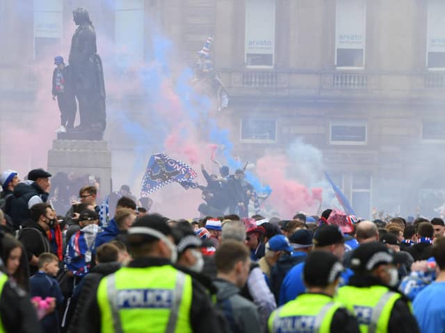 Police look on as Rangers fans celebrate in Glasgow's George Square. Several officers were injured. (Picture: Andy Buchanan/AFP via Getty Images)