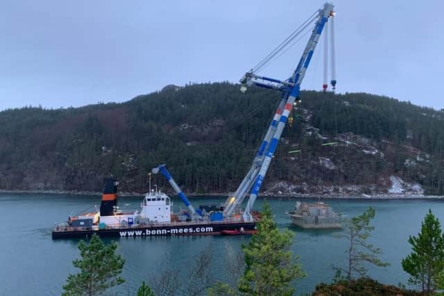 Floating crane Matador3 towing the Bakkafrost fish feed barge in Loch Carron after the vessel was raised from the site near Portree, on the Isle of Skye, where it sank during storm Arwen in November 2021