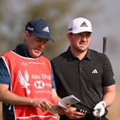 Connor Syme talks through a shot on the seventh tee at Yas Links with caddie Ryan McGuigan during day one of the Abu Dhabi HSBC Championship. Picture: Ross Kinnaird/Getty Images.