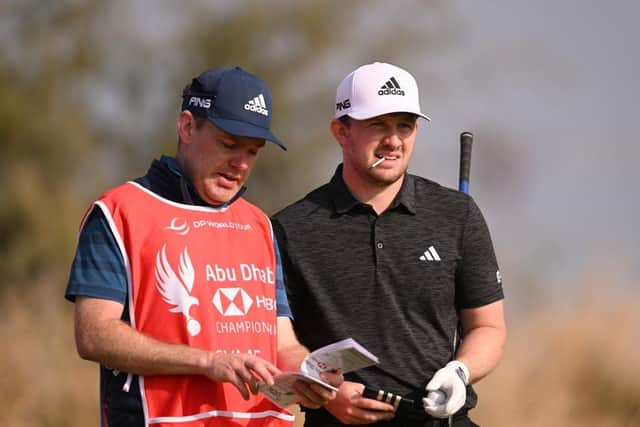 Connor Syme talks through a shot on the seventh tee at Yas Links with caddie Ryan McGuigan during day one of the Abu Dhabi HSBC Championship. Picture: Ross Kinnaird/Getty Images.