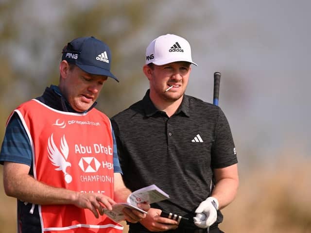 Connor Syme talks through a shot on the seventh tee at Yas Links with caddie Ryan McGuigan during day one of the Abu Dhabi HSBC Championship. Picture: Ross Kinnaird/Getty Images.