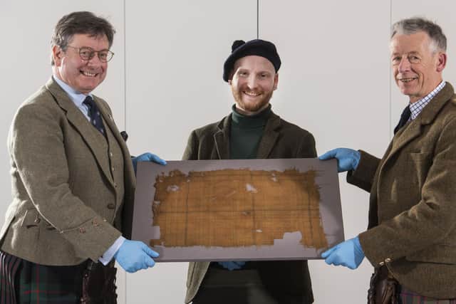 John McLeish, chair of the Scottish Tartans authority, V&A Dundee curator James Wylie and tartan historian Peter MacDonald have a close look at the Glen Affric tartan. Picture: Alan Richardson