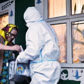 How voting can take place amid the Covid pandemic: an official in full PPE holds a mobile ballot box as a woman casts her vote in Moldova's presidential election in the village of Stetcani (Picture: Sergei Gapon/AFP via Getty Images)