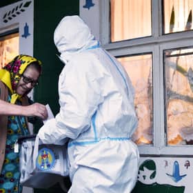 How voting can take place amid the Covid pandemic: an official in full PPE holds a mobile ballot box as a woman casts her vote in Moldova's presidential election in the village of Stetcani (Picture: Sergei Gapon/AFP via Getty Images)