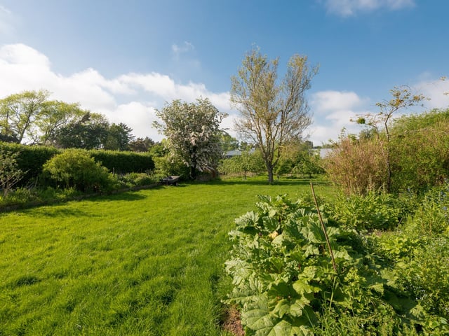 The grounds, which measure around an acre in total, include a cultivated garden, mature orchard and large grassed area