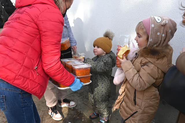 Ukrainian refugees children receive food in front of a temporary refugee centre at a primary school in Tiszabecs close to the Hungarian-Ukrainian border on March 3rd. Photo: Attila KISBENEDEK / AFP via Getty Images.