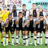 Germany players pose with their hands covering their mouths as they line up for the team photos prior to the FIFA World Cup Qatar 2022 Group E match between Germany and Japan at Khalifa International Stadium on November 23, 2022 in Doha, Qatar. (Photo by Alexander Hassenstein/Getty Images)