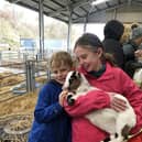 Ailsa and Fergus Milne enjoy a cuddle with a goat.