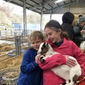 Ailsa and Fergus Milne enjoy a cuddle with a goat.