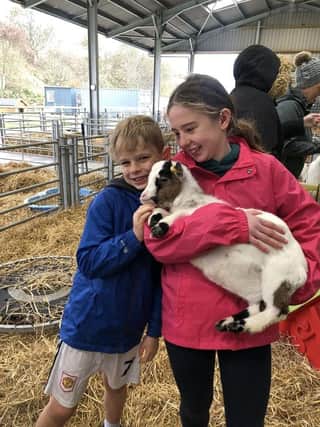 Ailsa and Fergus Milne enjoy a cuddle with a goat.