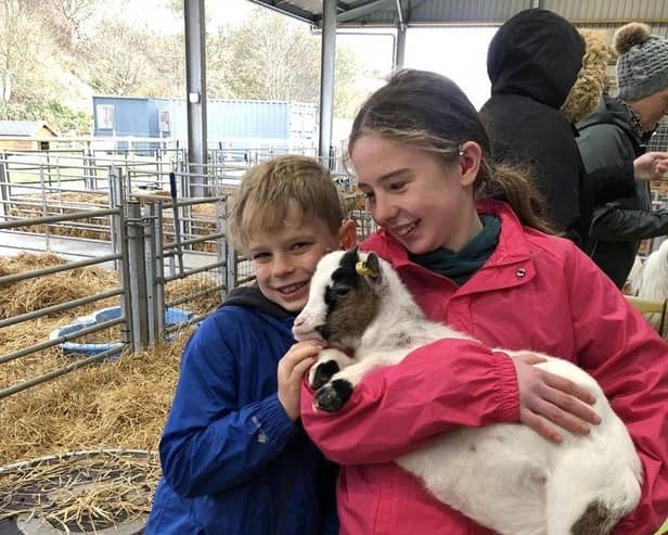 Ailsa and Fergus Milne enjoy a cuddle with a goat.