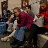 Kyiv residents pass the time in an underground metro station during an air raid alarm. Increased air alarms are becoming more commonplace with the recent drone strikes hitting the capital city.
