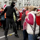 Belarusian pensioners argue with a law enforcement officer during a rally
