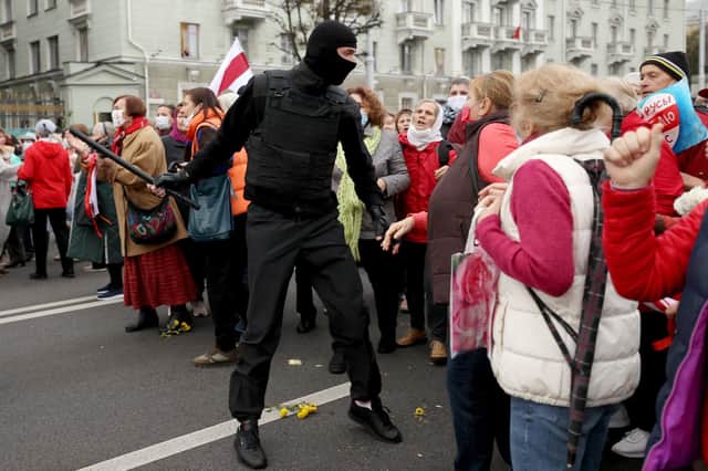 Belarusian pensioners argue with a law enforcement officer during a rally