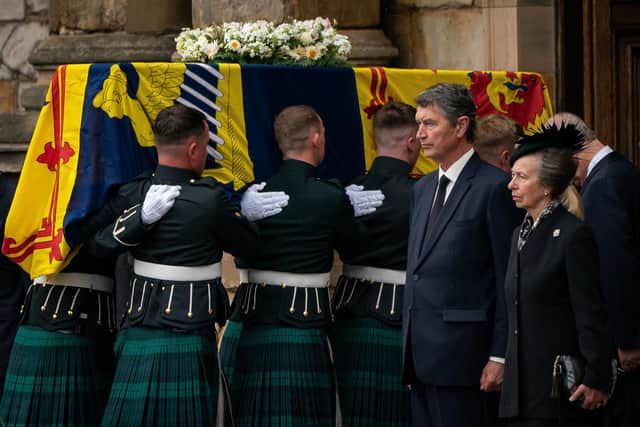 Vice Admiral Timothy Laurence and the Princess Royal stand solemnly as the coffin of Queen Elizabeth II, draped with the Royal Standard of Scotland, completes its journey from Balmoral to the Palace of Holyroodhouse in Edinburgh, where it will lie in rest for a day. Picture date: Sunday September 11, 2022.