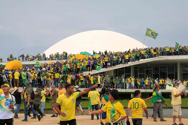 Supporters of Brazilian former President Jair Bolsonaro invade the National Congress in Brasilia on January 8, 2023. - Hundreds of supporters of Brazil's far-right ex-president Jair Bolsonaro broke through police barricades and stormed into Congress, the presidential palace and the Supreme Court Sunday, in a dramatic protest against President Luiz Inacio Lula da Silva's inauguration last week. (Photo by Sergio Lima / AFP) (Photo by SERGIO LIMA/AFP via Getty Images)