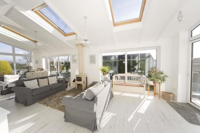 The spacious sun room provides plenty of space to relax or entertain guests.